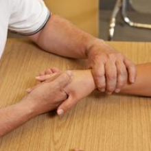 Clinician assessing and mobilizing patient’s wrist